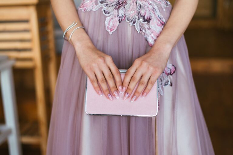 mulher de vestido rosa segurando uma clutch na mesma cor