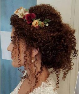 coque médio com tiara de flores, cabelo enrolado