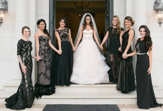 Madrinhas de casamento de preto. Os modelos dos vestidos escolhidos são diferentes, com renda e transparência.