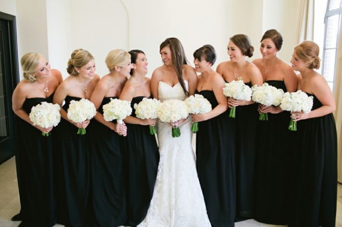 Madrinhas de casamento de preto e com modelo de vestido tomara que caia simples. Todas as madrinhas vestem o mesmo modelo.