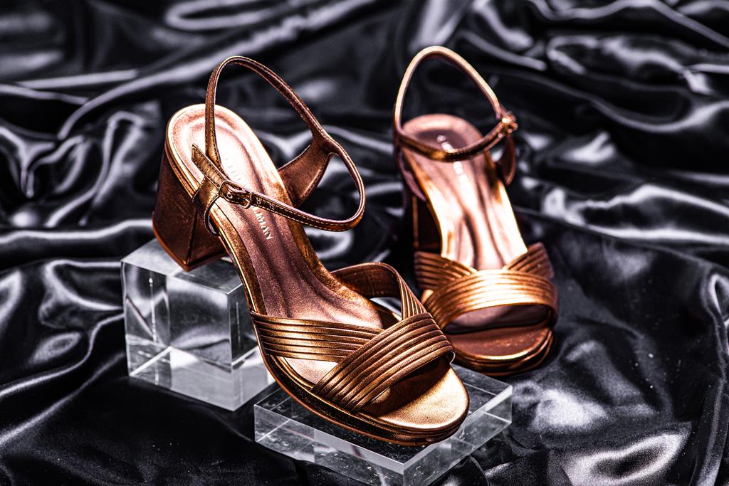 Sapato para mãe de noiva estilo sandália dourada com salto estilo bloco ambientada em tecido preto