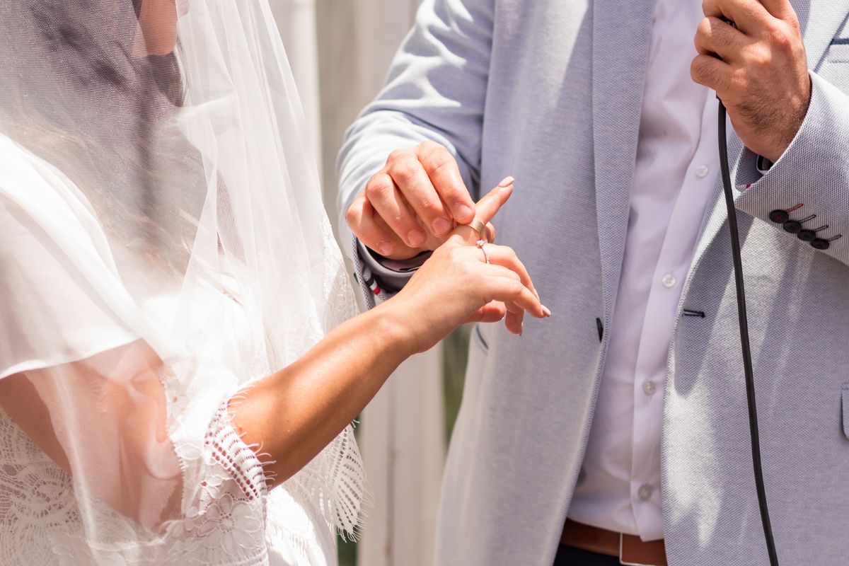noivo em um casamento judaico colocando um anel no dedo indicador direito da noiva
