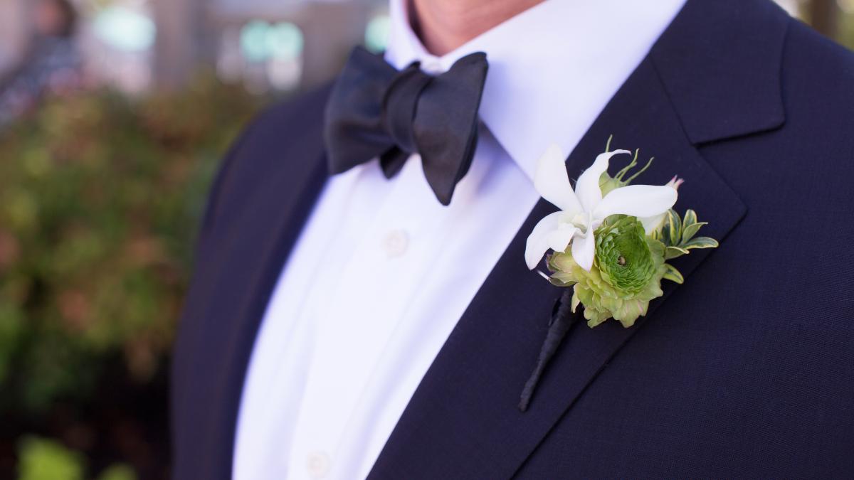 Homem de paletó com flores na lapela