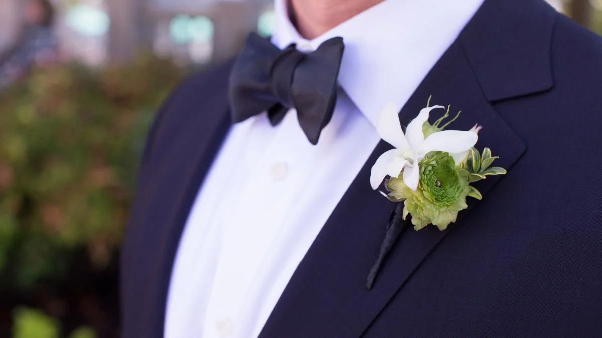 Homem de paletó com flores na lapela
