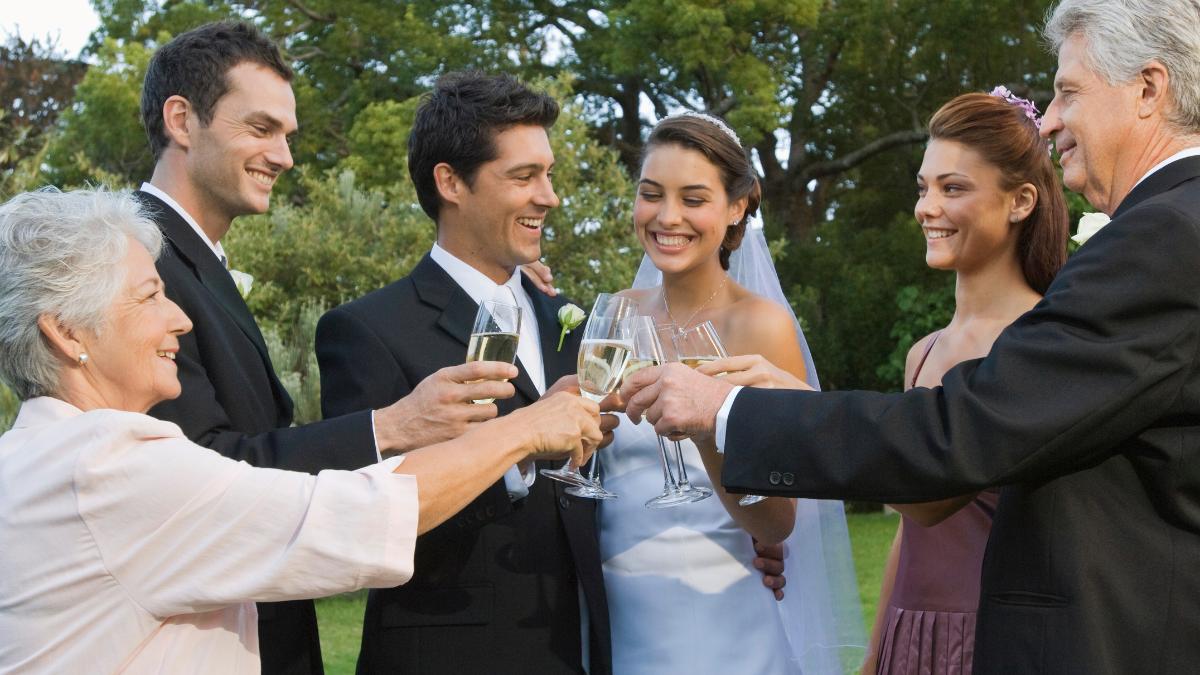 Casal e família com pais separados em casamento.