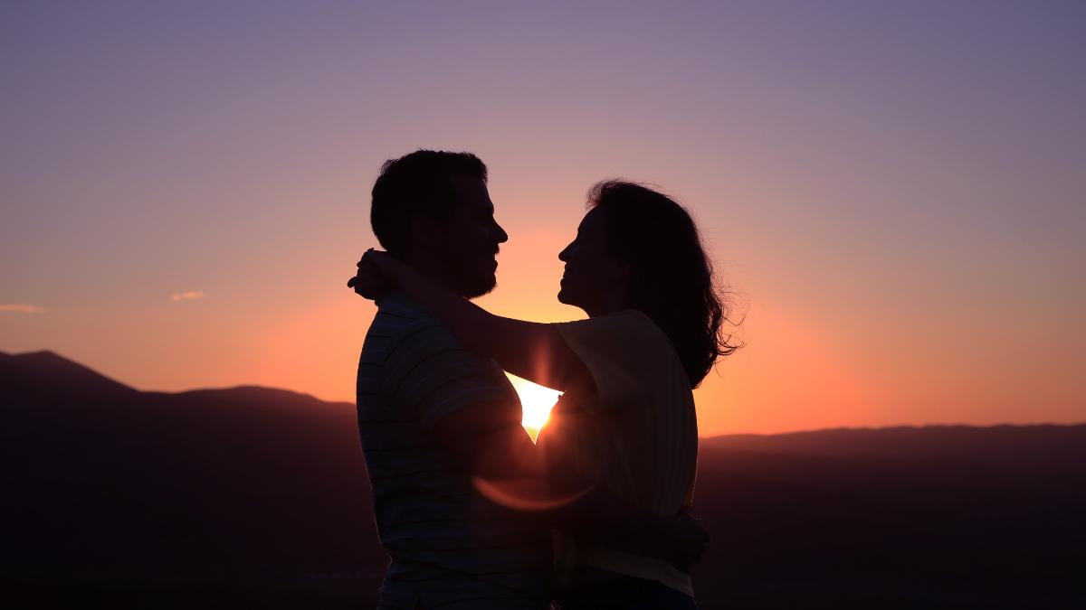 Casal frente ao por do sol.