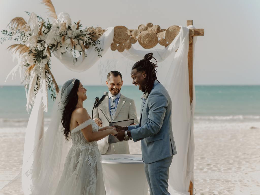 casal casando na praia e um celebrante