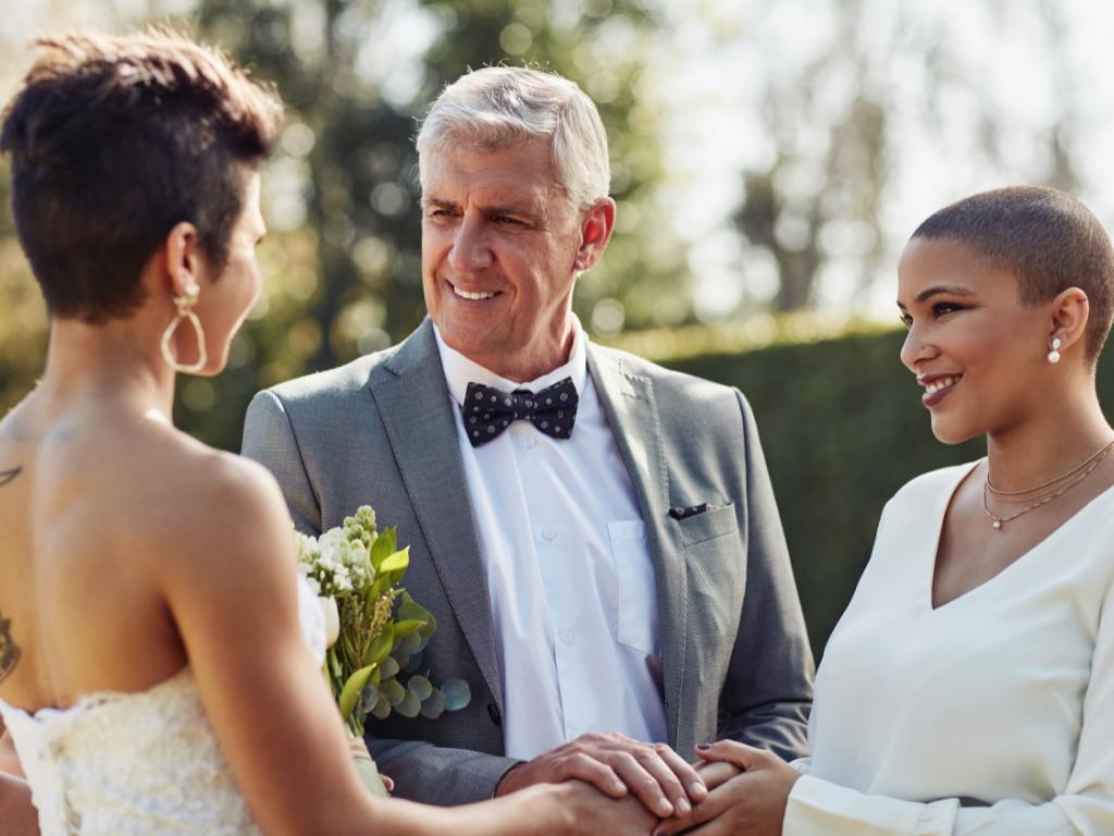 casal de mulheres negras se casamento e um celebrante de meia idade