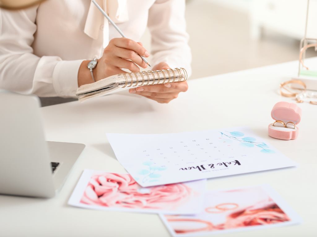 mulher segurando um papel e escrevendo e papeis e computador na mesa