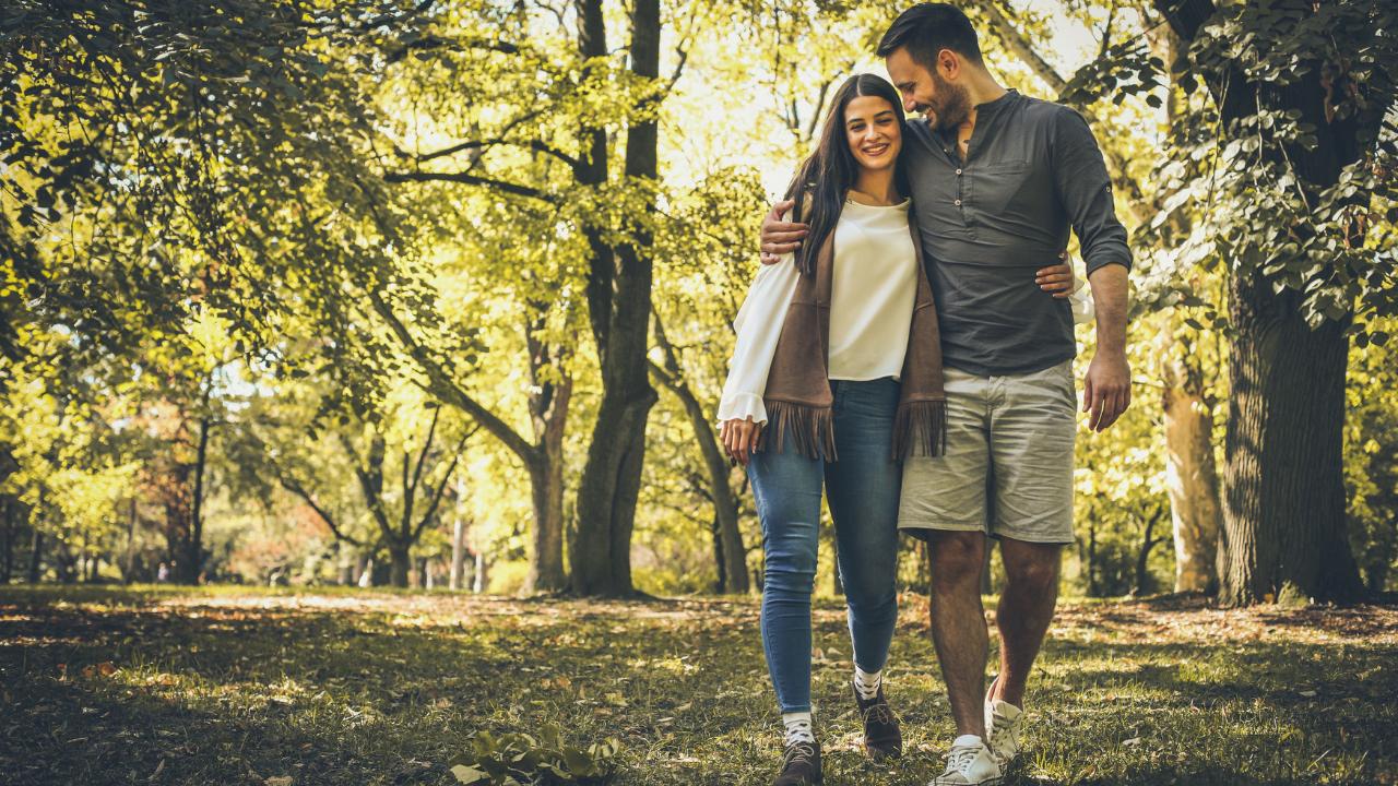 Casal de mulher e homem passeando no parque.