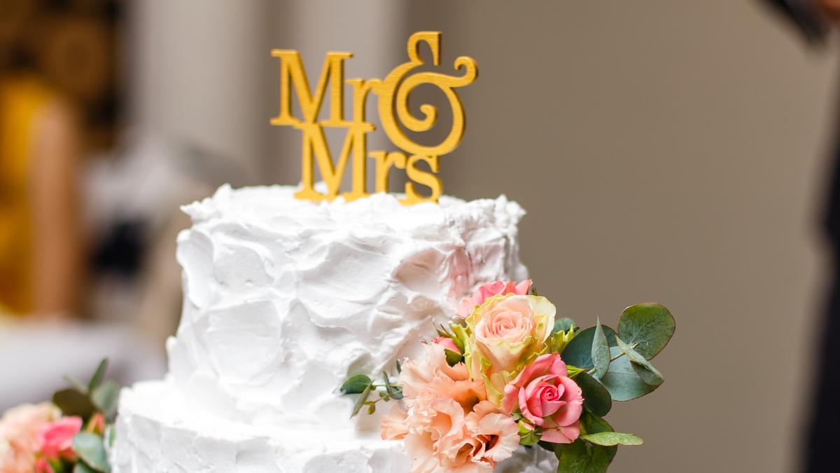 Topo de bolo de casamento com placa escrito "Mr & Mrs".