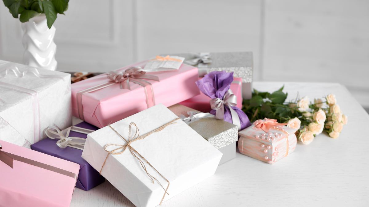 embalagens de presentes de casamento de diversas cores, como branco, rosa e lilás 