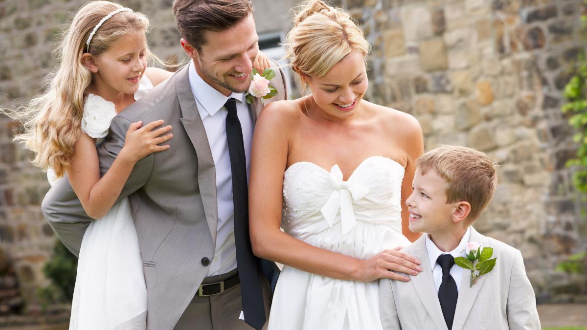 Casal com daminha e pajem em casamento.