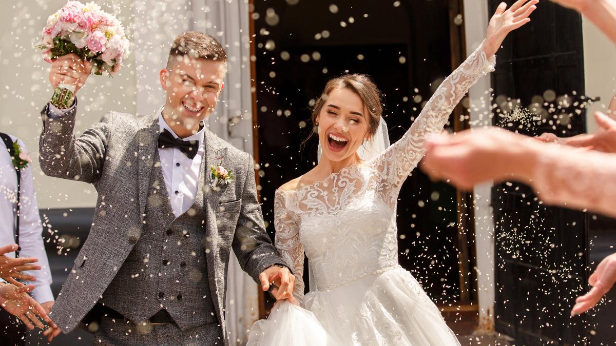 Casal saindo a igreja e recebendo chuva de arroz.