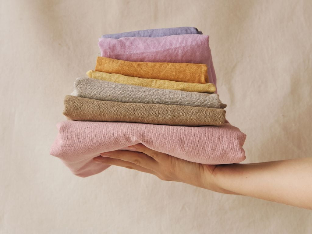 mao segurando lencois coloridos