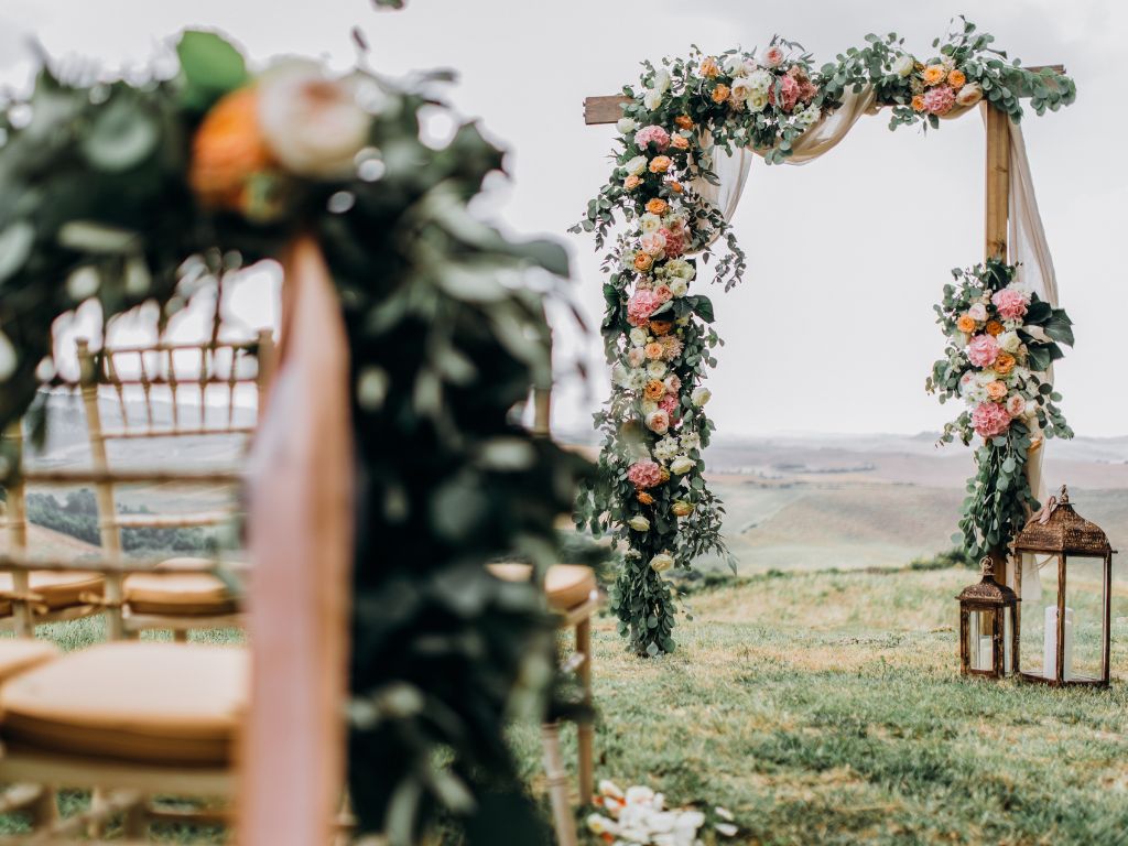 decoração de casamento no campo com cadeiras com flores coloridas 