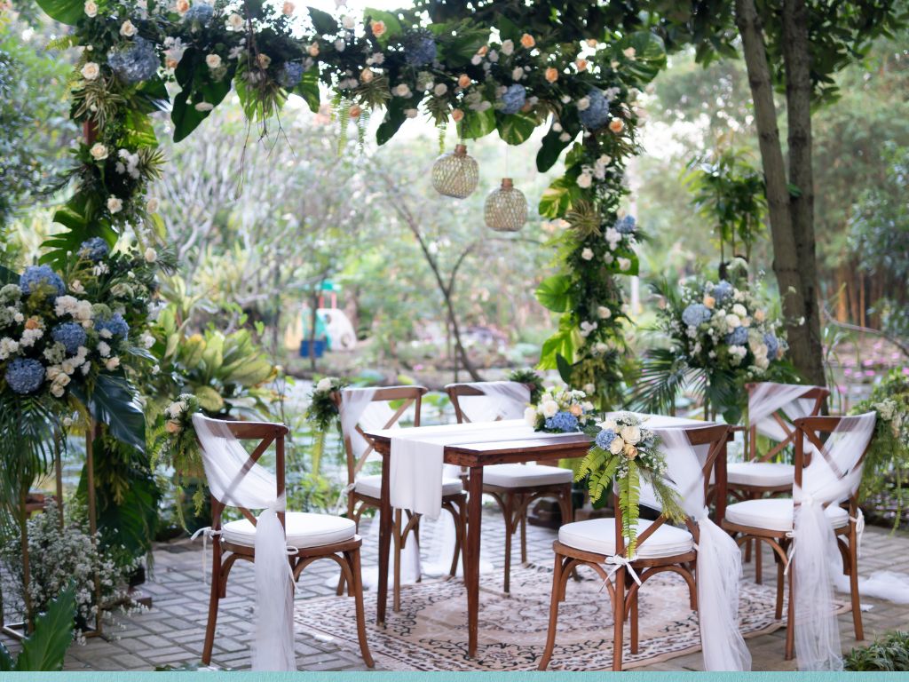 mesa com flores e tecidos brancos decorada para um casamento no campo