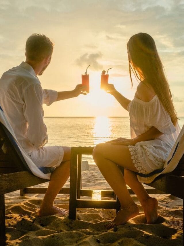 casal na praia brindando
