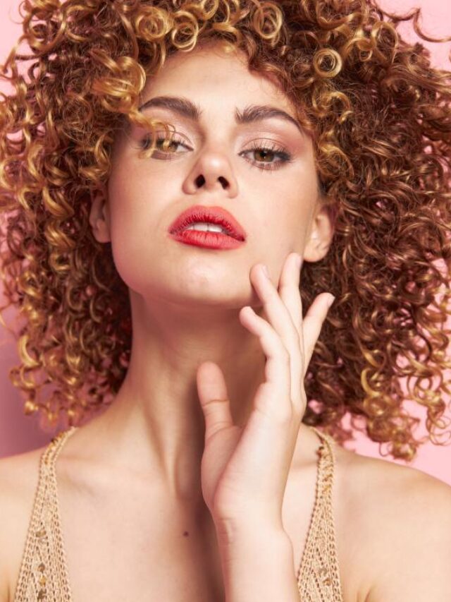 Mulher com cabelo cacheado contra fundo rosa
