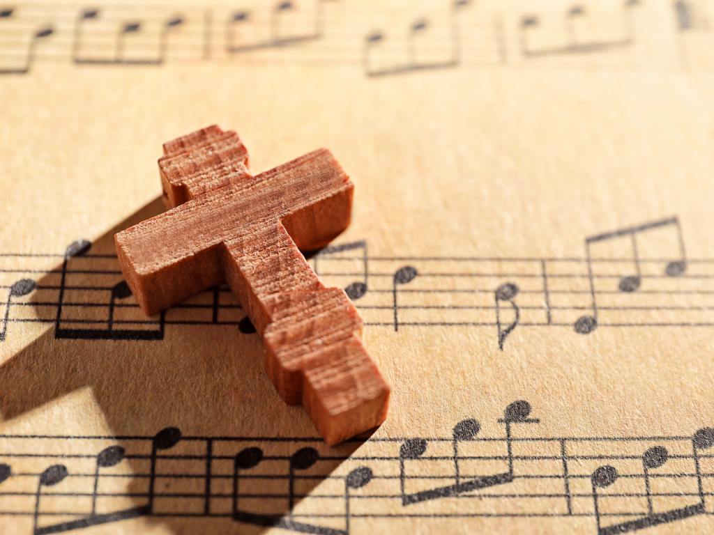 Cruz em cima de uma partitura musical