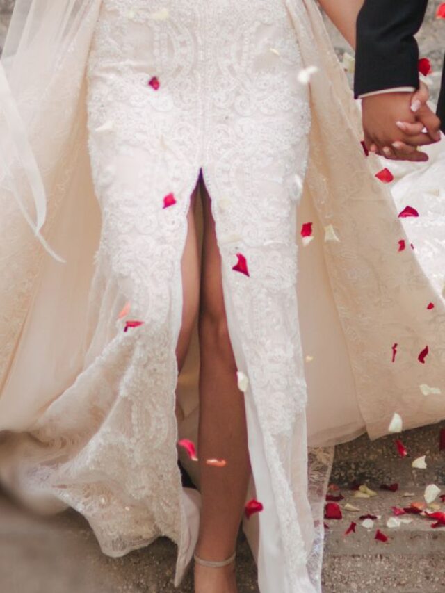 noiva com vestido de fenda saindo da igreja saindo de mãos dadas com o noivo