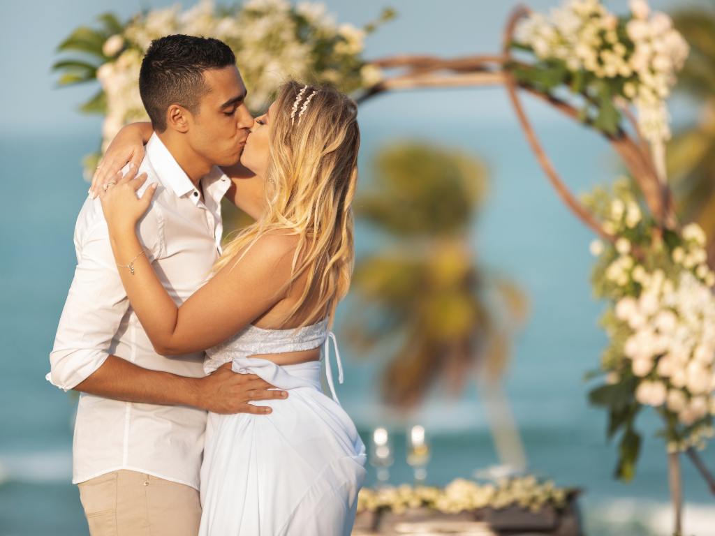Casal se beijando em um casamento tropical
