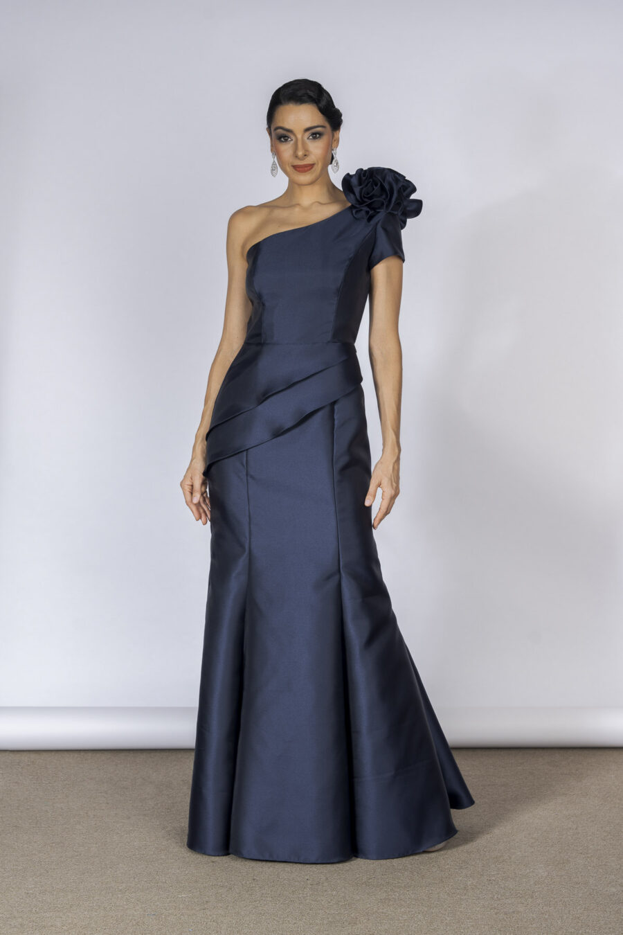 Vestido de festa longo com decote de um ombro só, na cor azul-marinho, com detalhe de flor feita a mão e modelagem sereia que valoriza a silhueta feminina, esse modelo é perfeito para mulheres elegantes e mães dos noivos