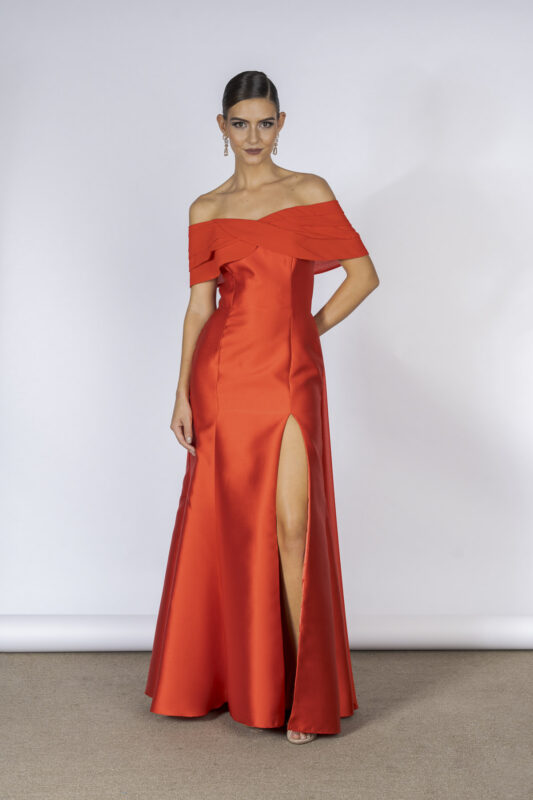 Vestido de festa longo com decote ombro a ombro e elegante semi sobrecapa, esse modelo em tecido de alfaiataria na cor vermelho é a aposta certa para você brilhar nos bailes e elegantes casamentos.