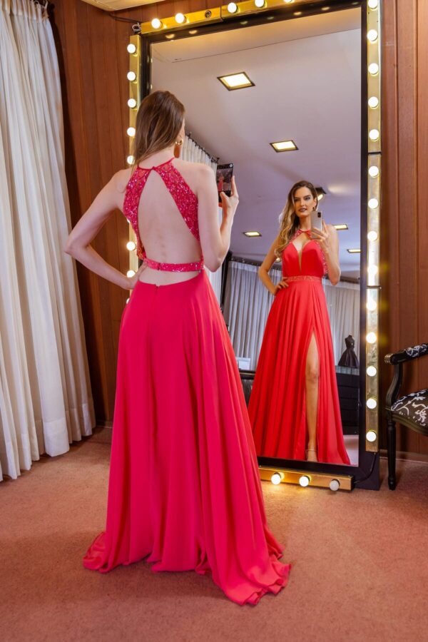 Vestido de festa longo na cor rosa, decote em V e saia com fenda.