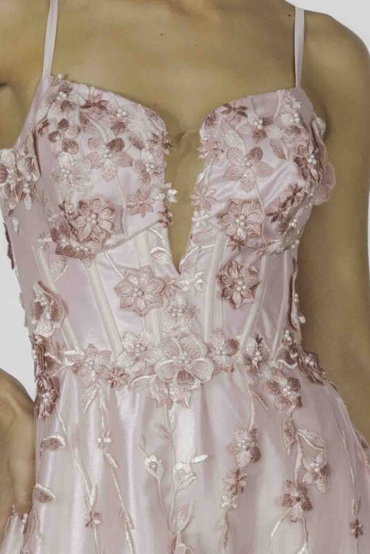 Detalhe do busto do vestido de festa com aplicações manuais de rendas e rosas feitas a mão