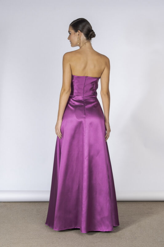 Costas do vestido de festa longo com modelagem tomara que caia e estilo romântico na cor rosa fúcsia em tecido de alfaiataria.