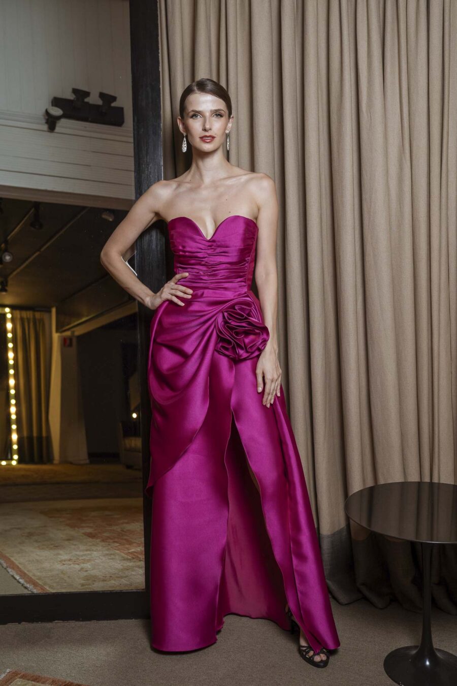 Vestido de festa longo na cor fúcsia, com decote tomara que caia e flor de tecido feita a mão na saia, modelo gaby.