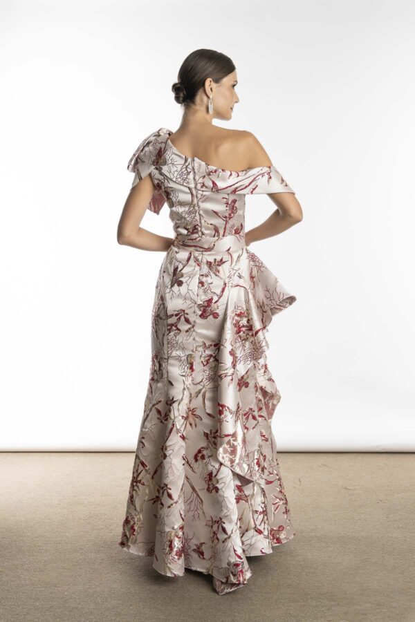 Costas do vestido de festa com detalhes de babados na saia, em tecido estampado estruturado.