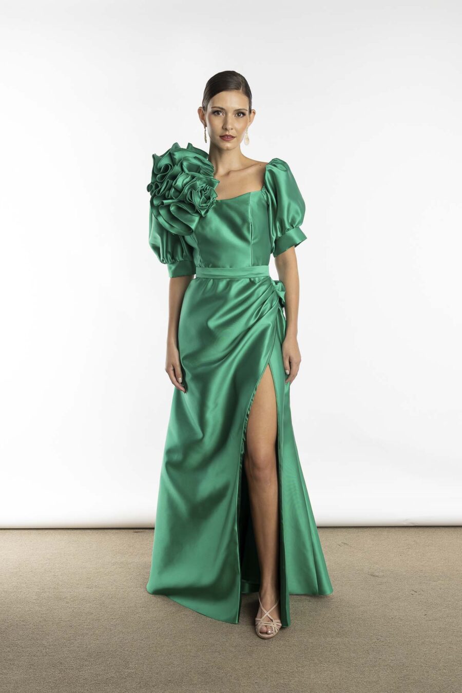 Vestido de festa longo com detalhe de flor feita a mão em tecido, aplicada no ombro do decote, na cor verde oliva e mangas 3/4 para jovens mães dos noivos e madrinhas de casamento.