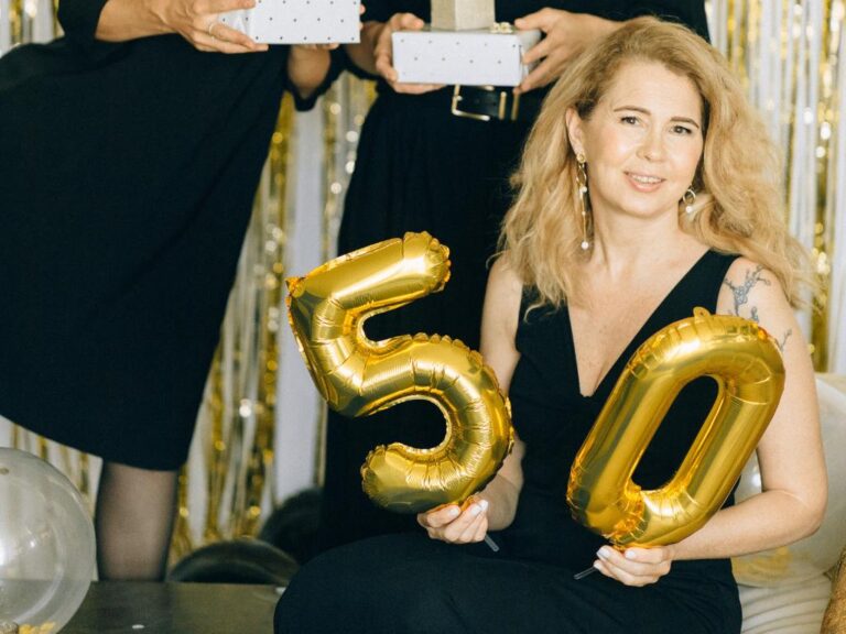 Mulher segurando balões de festa de 50 anos