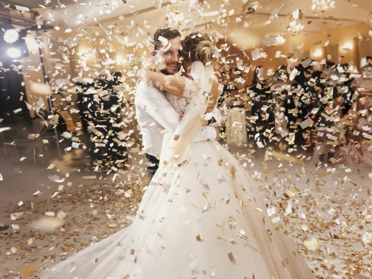Casal dançando em casamento dourado e branco