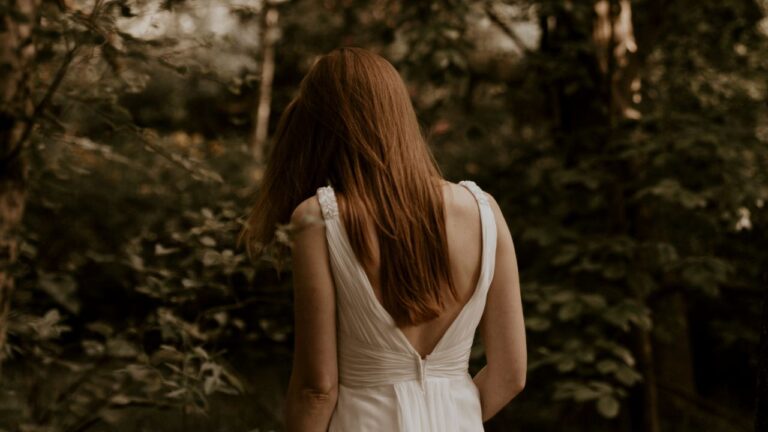 mulher de costas com vestido branco com decotes nas costas