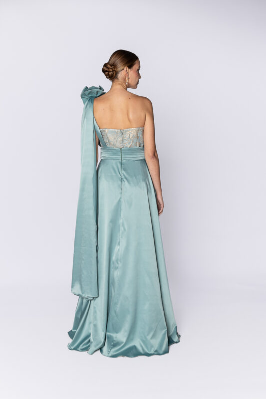 Costas do vestido de festa longo em jacquard exclusivo Lilli Gomes com pala e detalhe de flor removível, feito a mão em tecido cetim.