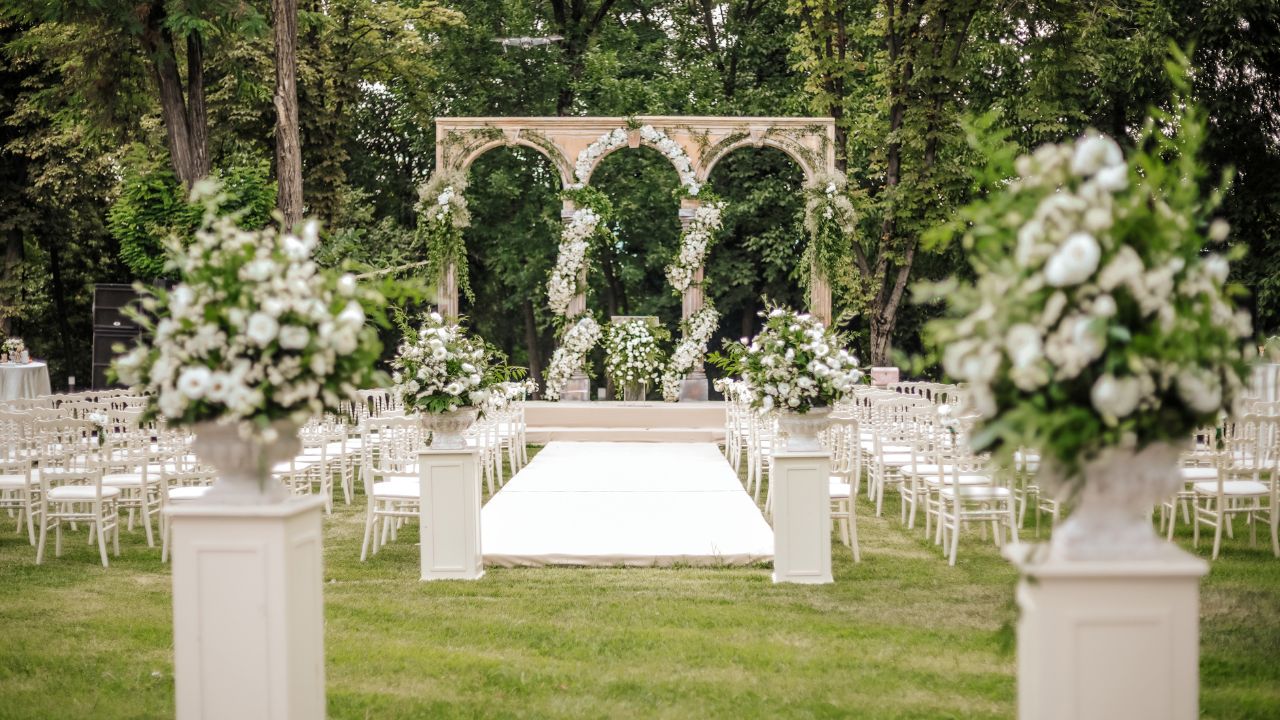 decoração de casamento verde e branco com pilares e flores ao ar livre