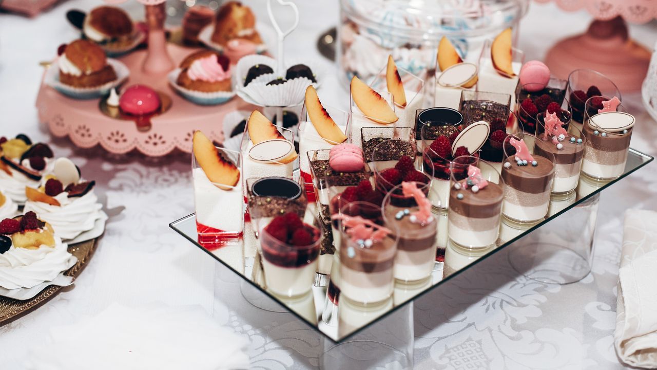 doces variados em copinhos em bandeja espelhada para chá de lingerie