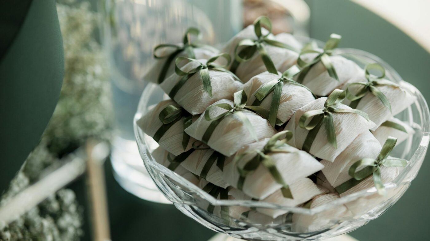 recipiente de vidro com bem-casados com fita verde
