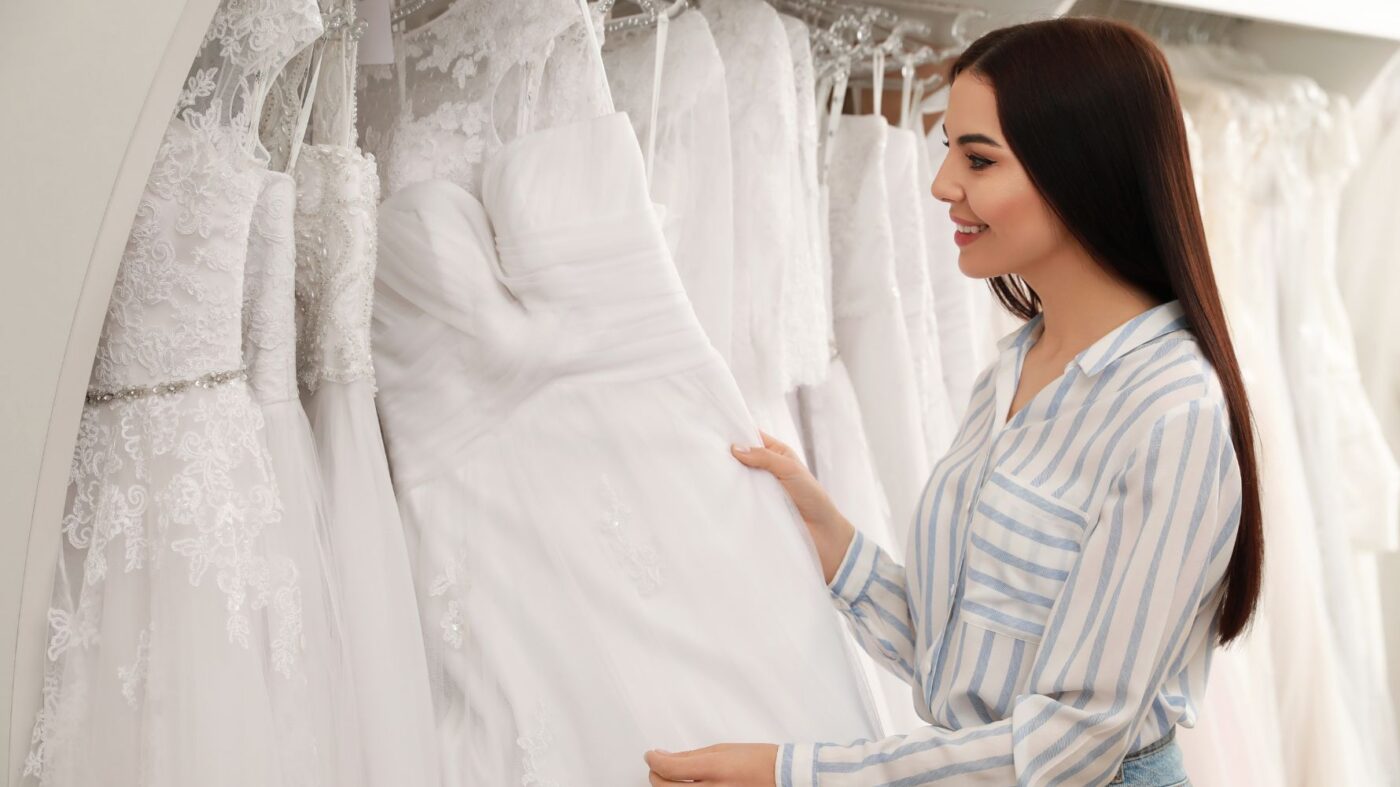 mulher olhando arara de vestidos de noiva
