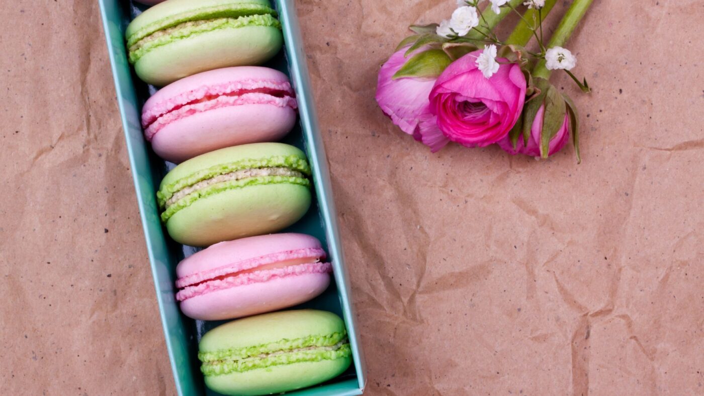 caixinha azul com macarons rosa e verde e uma flor do lado para substituir bem-casado como lembrancinha